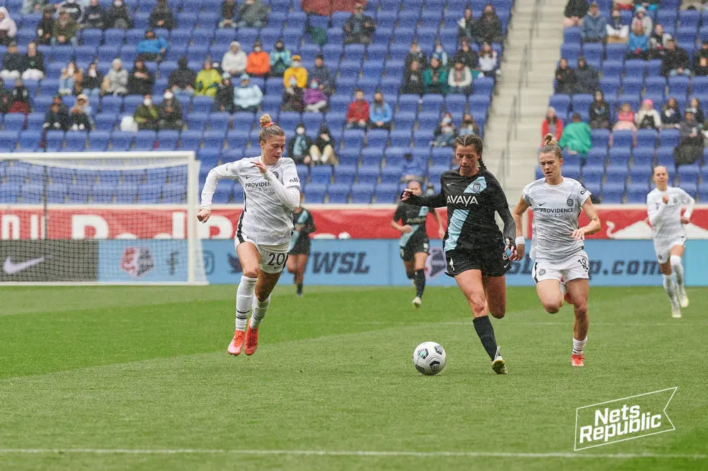 Paige Monaghan sprints down the field splitting two North Carolina Courage defenders at Red Bull Arena.